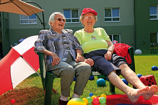 Zwei Seniorinnen sitzen auf einer Bank